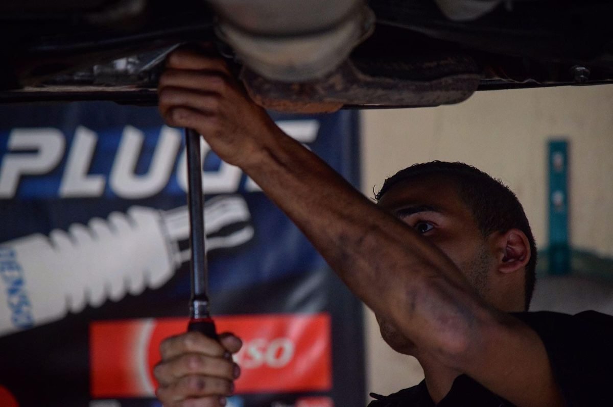 Mecánico de 1477 Auto Car Care trabajando debajo de un carro